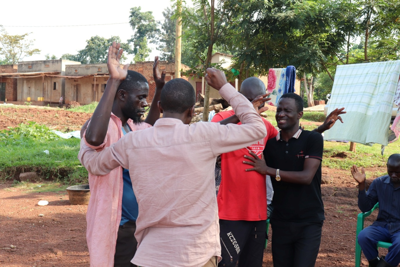 Church leaders praying together during an ENMI community visit